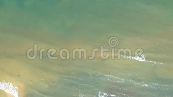 在浅海海岸绿松石水中游泳者的空中景色视频的预览图