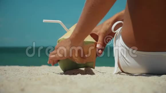 女人喝着新鲜的椰子水用吸管在海滩上享受有趣的假期3杯视频的预览图