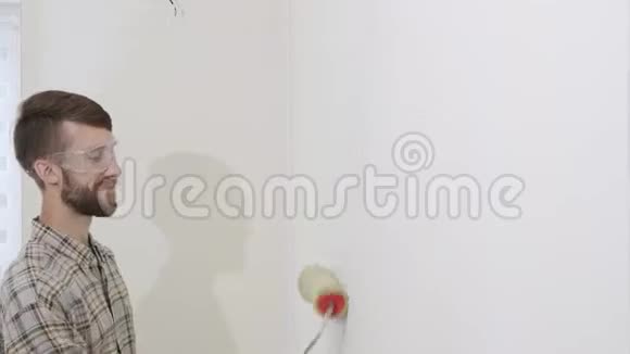 画家在工作用滚筒画墙画家的房子概念视频的预览图