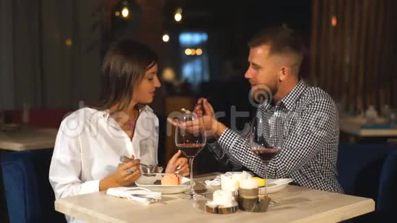 年轻夫妇在餐馆吃饭一个年轻人用奶酪蛋糕喂他的女朋友视频的预览图