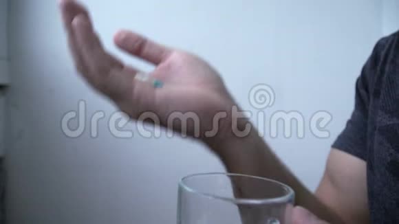一个人喝止痛药在灯光背景后面视频的预览图