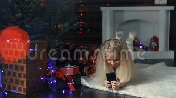 坐在圣诞树下拍照的女孩视频的预览图