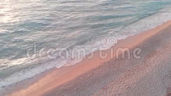 空中无人驾驶飞机拍摄的日落时分海浪在海滩上破碎的画面视频的预览图
