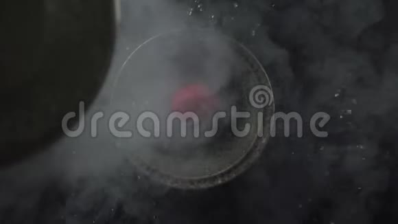 碗里草莓上流动的液体和烟雾的俯视图视频的预览图