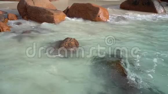 塞舌尔普拉斯林岛波浪在大石头上翻滚热带海岛豪华度假旅游休闲度假视频的预览图