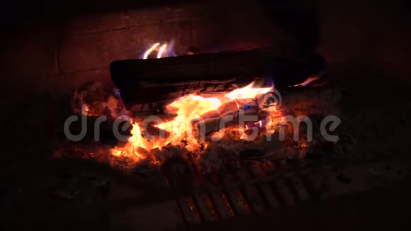 在黑暗中壁炉里燃烧的木柴上的火焰视频的预览图