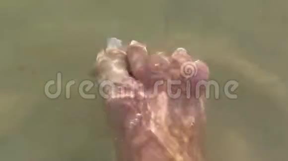 一个女人的脚她的脚趾在湖水中移动视频的预览图