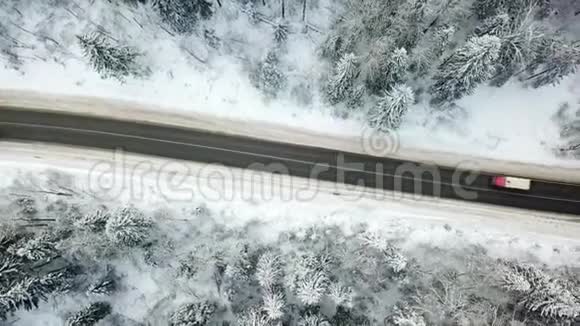冬天森林里的路空中观景过路车卡车视频的预览图