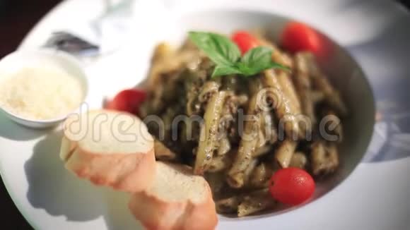 装饰好的煮面俯视图与西红柿大蒜罗勒叶帕尔马干酪和面包一起放在盘子里视频的预览图