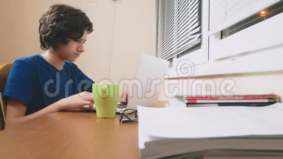 少年把茶倒在笔记本电脑上做作业在线学习4K特写视频的预览图