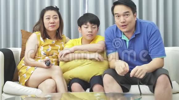 亚洲家庭父子在沙发上缓慢移动微笑着看着镜头视频的预览图