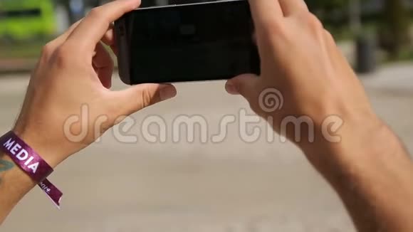 手握智能手机拍摄地标全景照片视频的预览图
