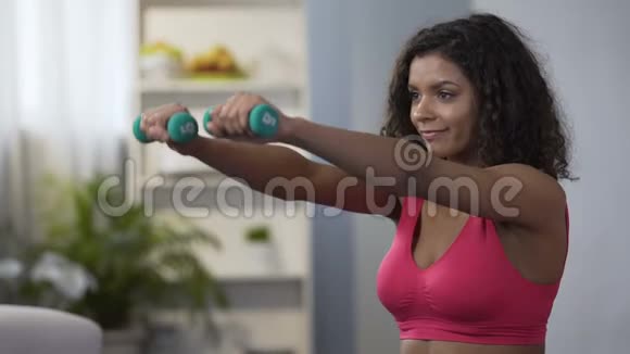 有魅力的女人举起哑铃积极的生活方式体育锻炼健身视频的预览图