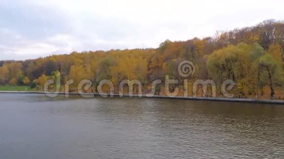 从漂浮在河上的船上观赏五彩缤纷的秋天公园的石廊视频的预览图