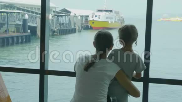 年轻的母亲和小女儿在海港休息室等待航行视频的预览图