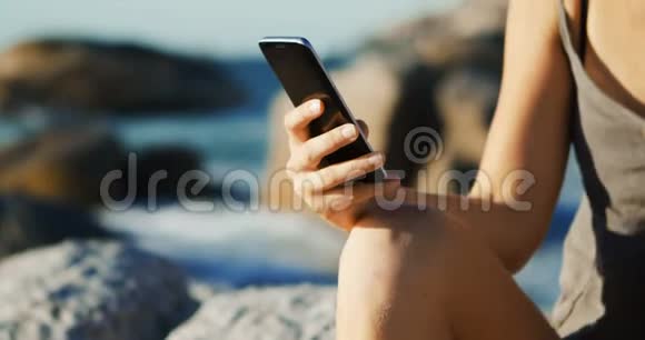 女排队员在沙滩上用手机4k视频的预览图