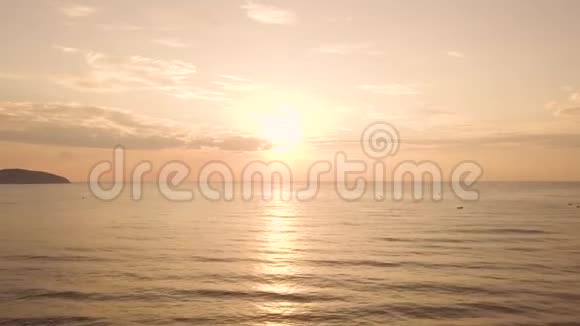 在夏季海滩的海水上空鸟瞰五彩缤纷的日出金色天空和阳光下美丽的日落视频的预览图