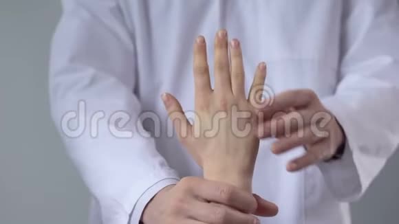 创伤学家移动病人的手腕评估损伤的严重程度特写视频的预览图