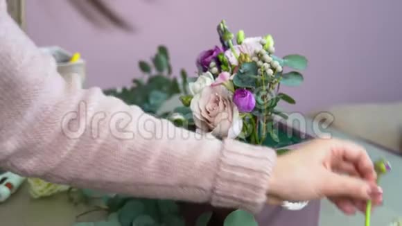 花艺师用红莲风信子牡丹红竹康乃馨玫瑰等植物配制花材时切花视频的预览图