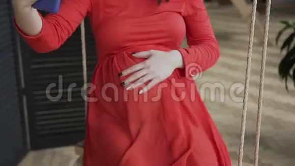 快关门一名穿着红色长裙的孕妇通过社交网络通过无线网络聊天视频的预览图