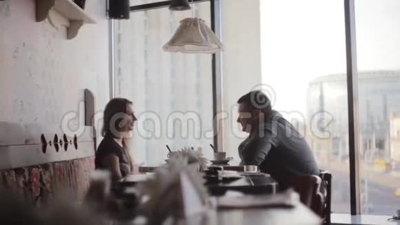 一个年轻的男人和女人互相看着对方交谈窗外的城市街景不错视频的预览图