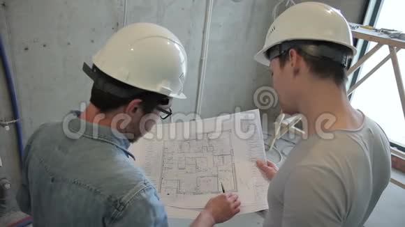 建筑工人在新房子的公寓进行维修根据图纸和蓝图检查参数视频的预览图