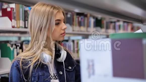 大学图书馆学生女孩在书架上看书视频的预览图