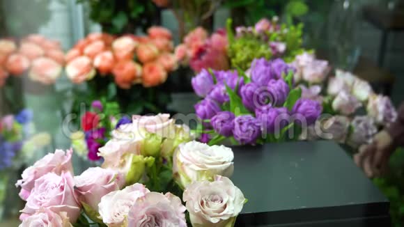 花商在花店里插花把美丽的丁香玫瑰放在前面视频的预览图