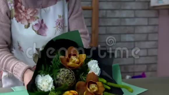 把花店里的花束用绿色包装纸包好菊芋橙兰白色康乃馨脱脂视频的预览图