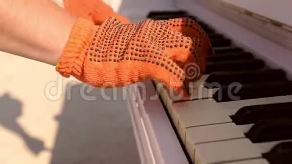 钢琴演奏者手的特写手套在键盘上演奏男人钢琴键盘上戴手套的手视频的预览图
