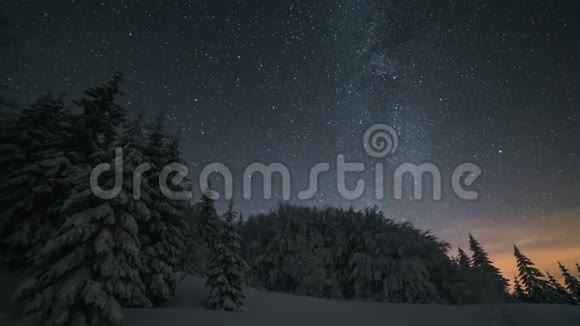 圣诞节的冬夜风景星空在白雪皑皑的树木上移动天文时间流逝放大视频的预览图