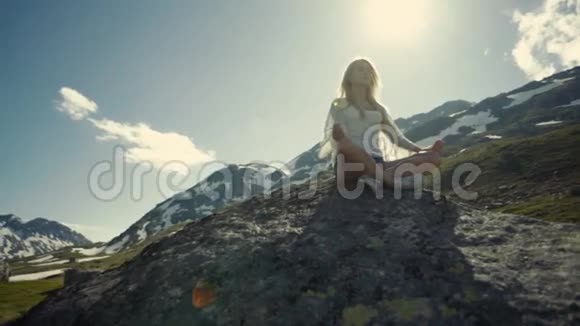 平静的女孩正在山里沉思灿烂的阳光在背景上视频的预览图