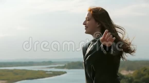 一个红头发的小女子站在山上的肖像女孩自然的背景风景如画视频的预览图