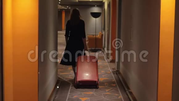 带着手提箱走到酒店走廊房间的女人视频的预览图