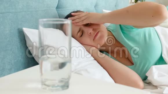 特写4k镜头年轻的患病妇女头痛躺在床上和饮水视频的预览图