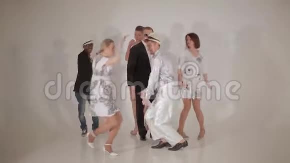 三个可爱的女孩和三个迷人的跨种族男人在白色的工作室跳舞视频的预览图