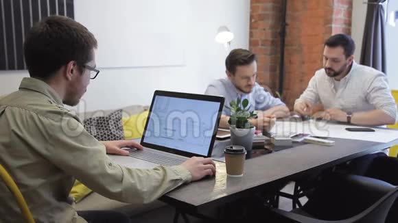 两个年轻人在办公室里用图纸看纸视频的预览图