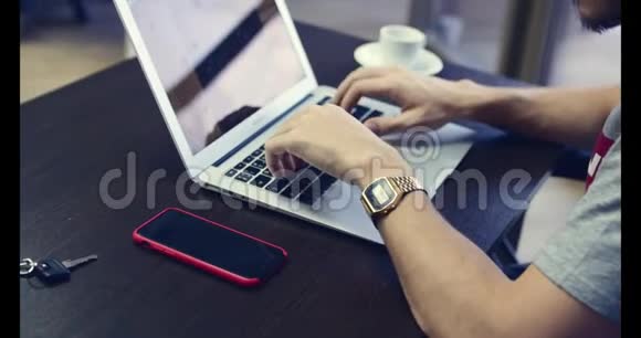 年轻的商人戴着眼镜手上拿着钟坐在桌子旁在电脑上工作4K视频的预览图