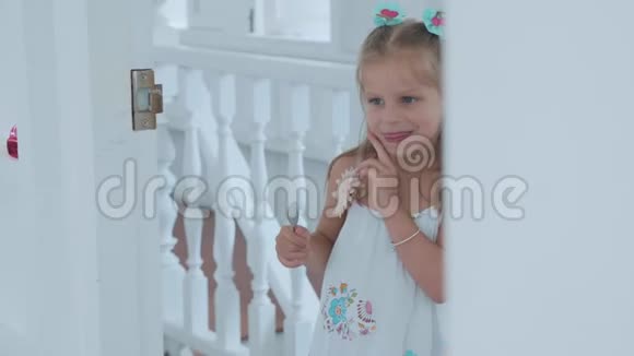 小可爱的小女孩用有趣的情绪透过房间的门口偷看视频的预览图