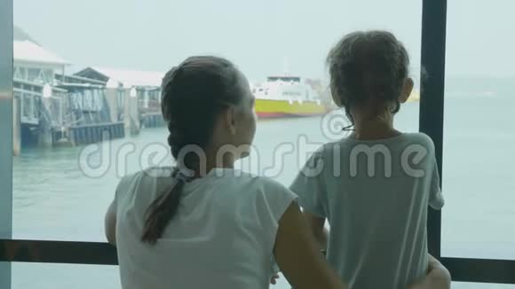 年轻的母亲和小女儿在海港休息室等待航行视频的预览图