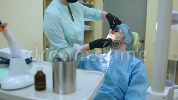 医生和病人在牙科办公室检查口腔医疗器械在前台视频的预览图