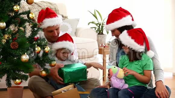 可爱的家庭在地板上打开圣诞礼物视频的预览图