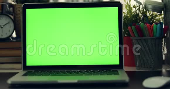 绿色屏幕笔记本电脑的多利拍摄黑暗的办公室完美地放置你自己的图像或视频正在使用的绿色技术屏幕视频的预览图