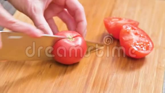 女性手拿刀的特写是在木切割板上切西红柿做沙拉家庭厨房视频的预览图