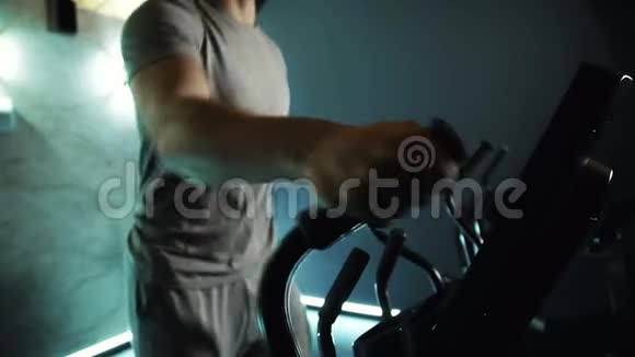 年轻男性运动员的苗条身体在现代健身房做交叉教练运动慢动作视频的预览图