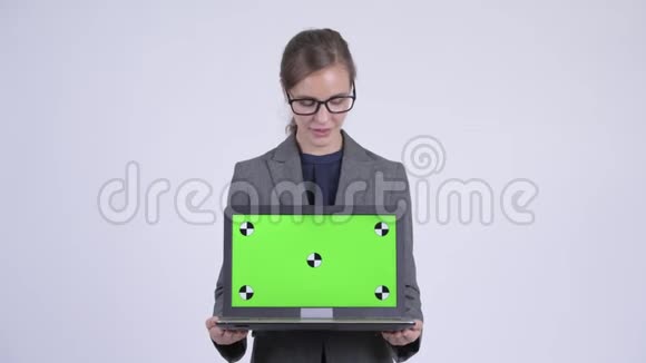 年轻快乐的女商人一边说话一边展示笔记本电脑视频的预览图