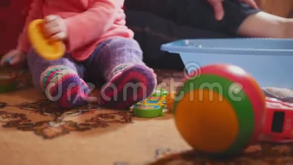 可爱的小女孩和她漂亮的奶奶坐在地上玩着五颜六色的玩具视频的预览图