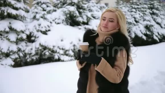 雪域公园里拿着杯咖啡的女孩画像视频的预览图