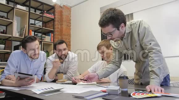 工作人员在办公室里和平板电脑讨论业务视频的预览图