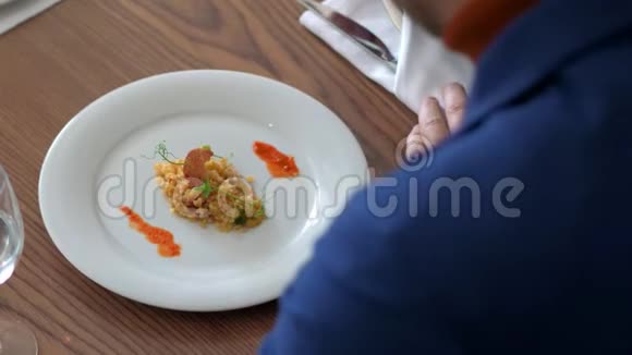 男士饮食博主在餐馆里用叉子和刀子吃牛腿菜视频的预览图
